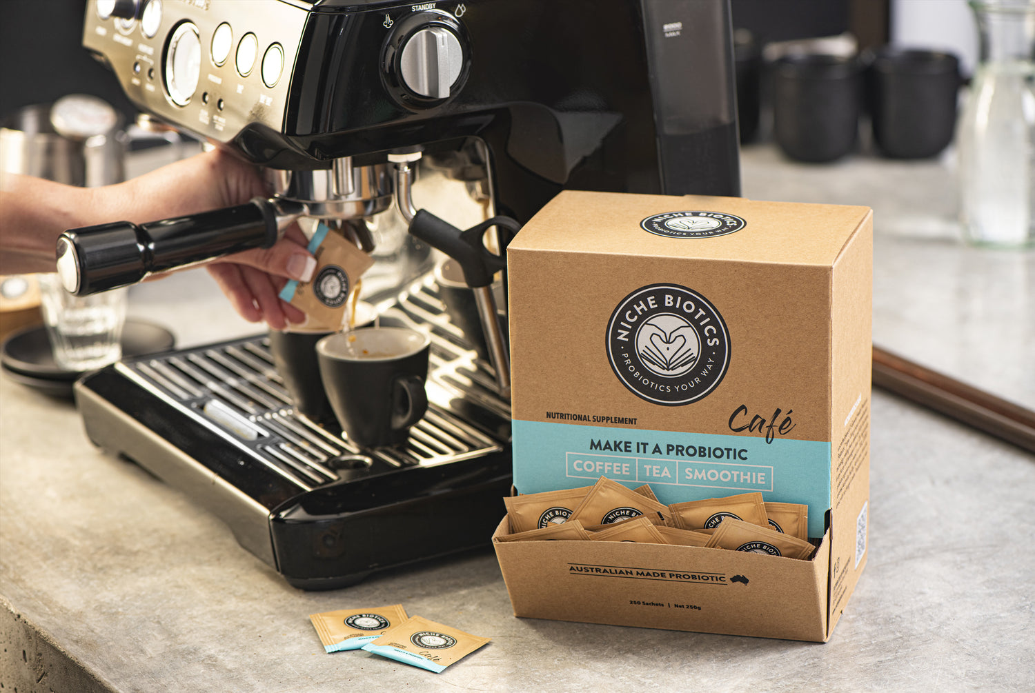 Niche Biotics' Probiotics Cafe sachets next to a coffee machine